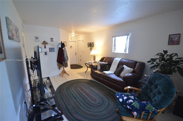 living room with a textured ceiling and light tile patterned floors