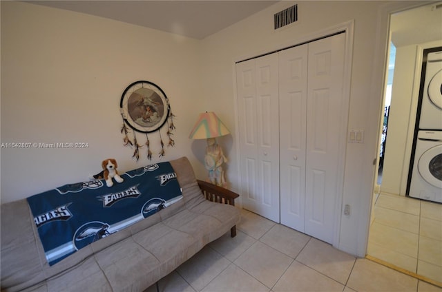 interior space with stacked washer / dryer and light tile patterned flooring