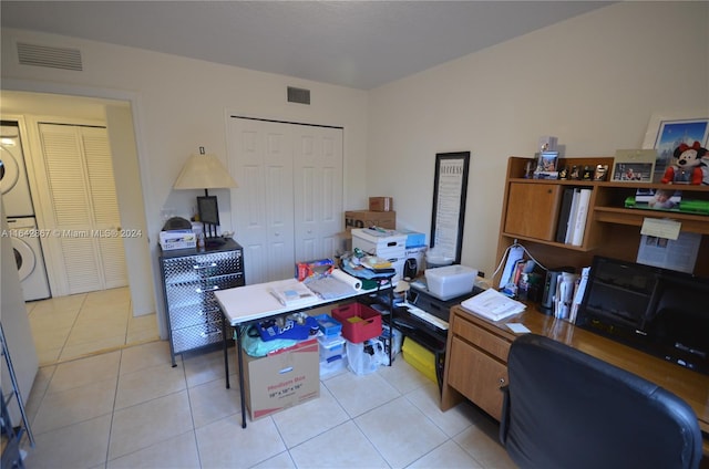 office featuring stacked washer and dryer and light tile patterned floors