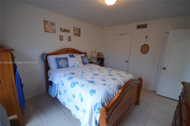 bedroom with a textured ceiling and light tile patterned floors