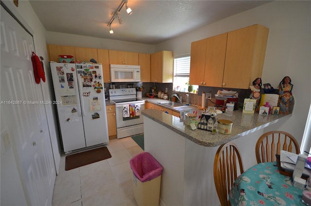 kitchen with tasteful backsplash, sink, light tile patterned floors, kitchen peninsula, and white appliances