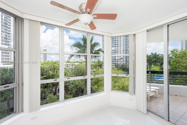 unfurnished sunroom with ceiling fan and a wealth of natural light