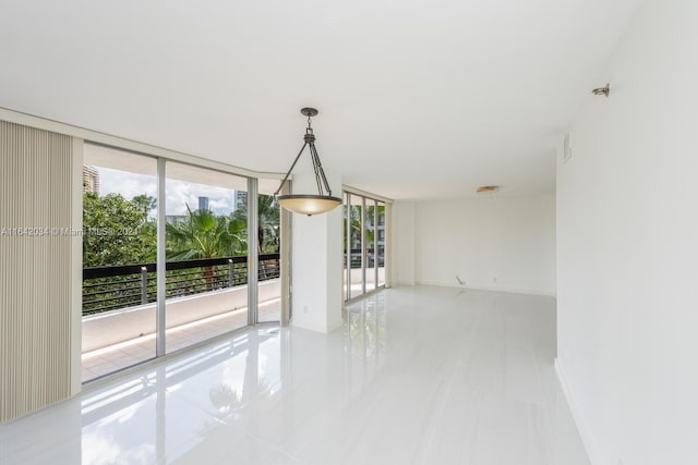 spare room with tile patterned floors, a wall of windows, and plenty of natural light