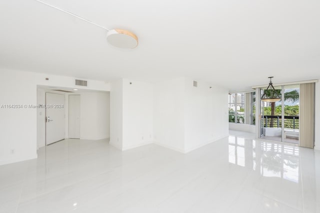 empty room featuring floor to ceiling windows and light tile patterned floors