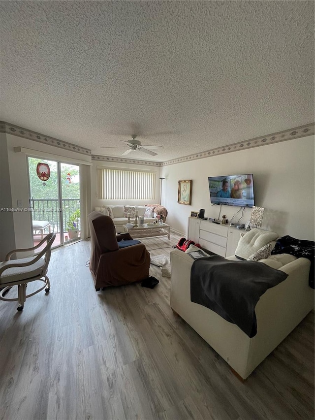 living room with hardwood / wood-style flooring, a textured ceiling, and ceiling fan