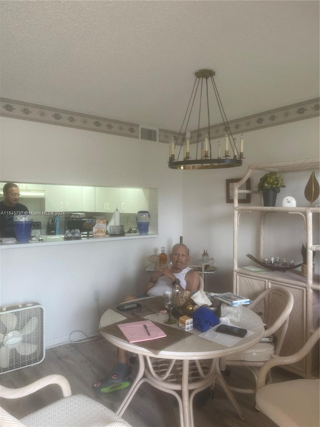 dining room with a textured ceiling and hardwood / wood-style floors