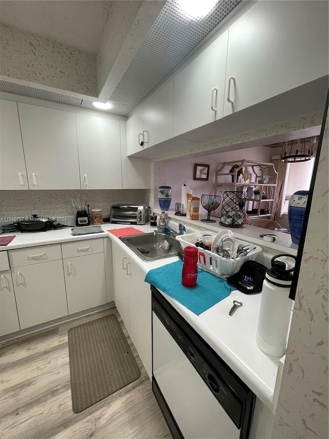 kitchen with sink, light hardwood / wood-style flooring, white cabinets, and dishwasher