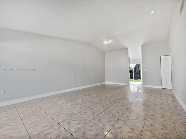 tiled spare room with lofted ceiling