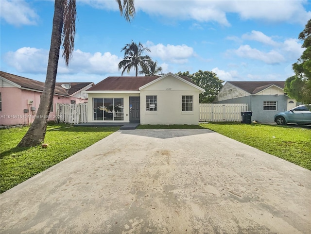 view of front of property featuring stucco siding, fence, and a front yard