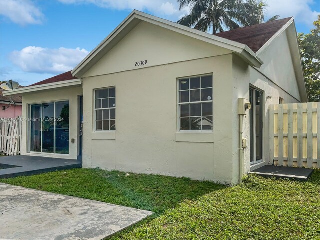 back of house with a patio area and a lawn