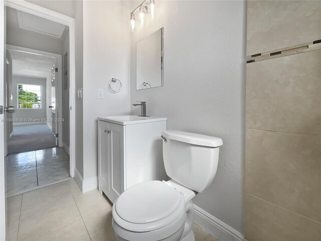 bathroom featuring baseboards, vanity, toilet, and tile patterned floors