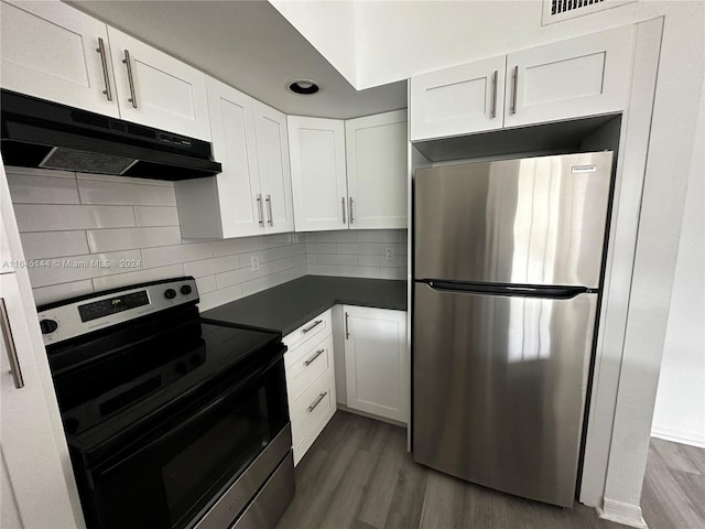 kitchen featuring electric range, white cabinetry, hardwood / wood-style flooring, and stainless steel refrigerator