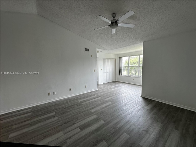 unfurnished room featuring lofted ceiling, dark hardwood / wood-style flooring, ceiling fan, and a textured ceiling