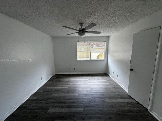 spare room featuring ceiling fan, dark hardwood / wood-style floors, and a textured ceiling