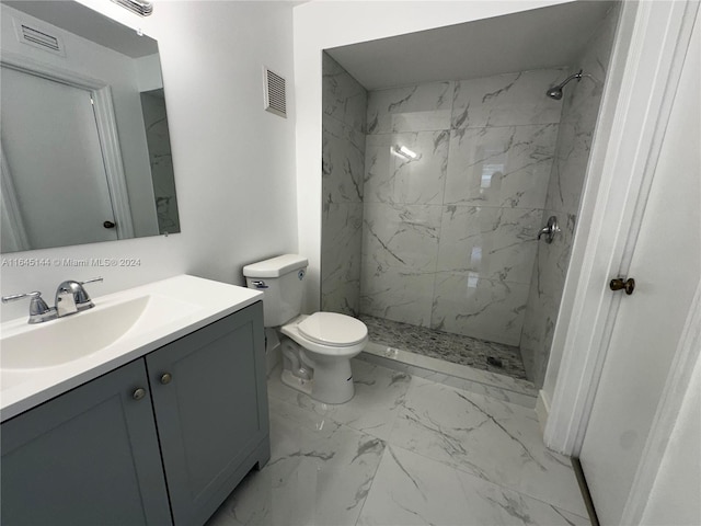 bathroom with vanity, toilet, and a tile shower