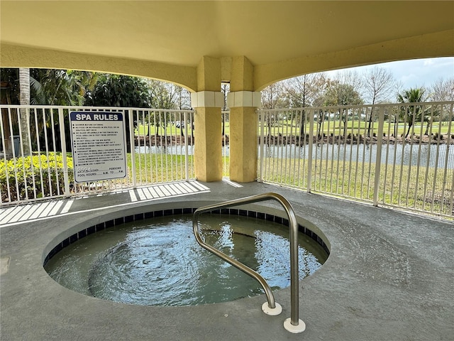 view of pool featuring a community hot tub and a water view