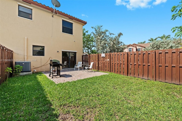 rear view of property with a patio area, central AC unit, and a lawn