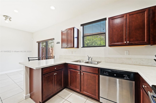 kitchen with kitchen peninsula, dishwasher, sink, and light tile patterned floors