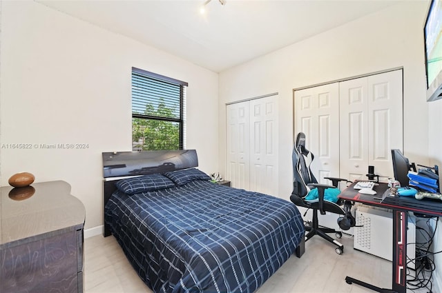 bedroom with multiple closets and light wood-type flooring