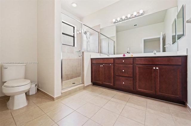 bathroom featuring toilet, a shower with shower door, vanity, and tile patterned flooring