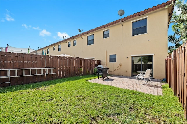 rear view of property featuring a yard and a patio