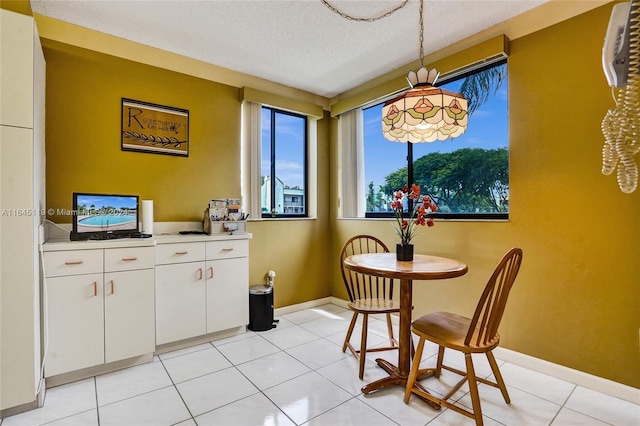 dining space with light tile patterned floors and a textured ceiling