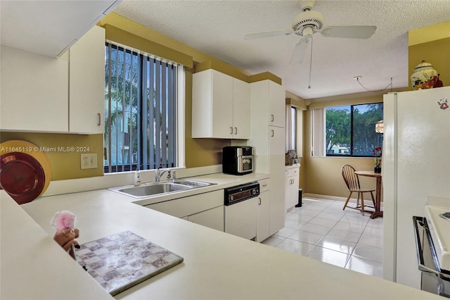 kitchen with white appliances, ceiling fan, sink, light tile patterned floors, and white cabinetry