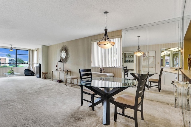 dining area with light carpet and a textured ceiling