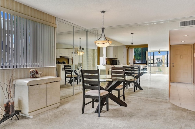 dining area featuring light carpet, a textured ceiling, and wooden walls