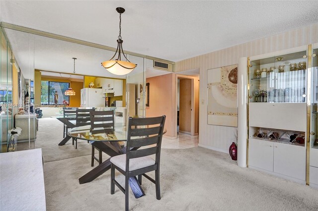 carpeted dining room with a textured ceiling and a healthy amount of sunlight