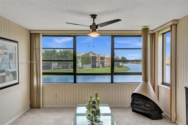 sunroom with a water view and ceiling fan