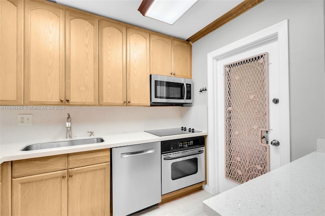 kitchen featuring light brown cabinets, stainless steel appliances, and sink