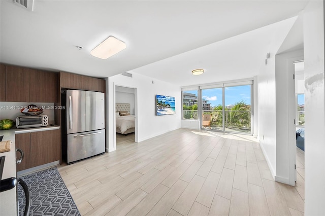 kitchen featuring light hardwood / wood-style flooring and stainless steel refrigerator