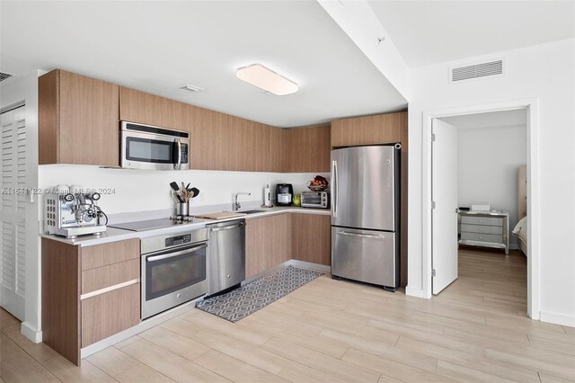 1600 SW 1st Ave Unit 614, Miami, FL 33129 - kitchen with light wood finished floors, stainless steel appliances, light countertops, visible vents, and modern cabinets