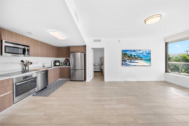 kitchen featuring sink, light tile patterned floors, and appliances with stainless steel finishes