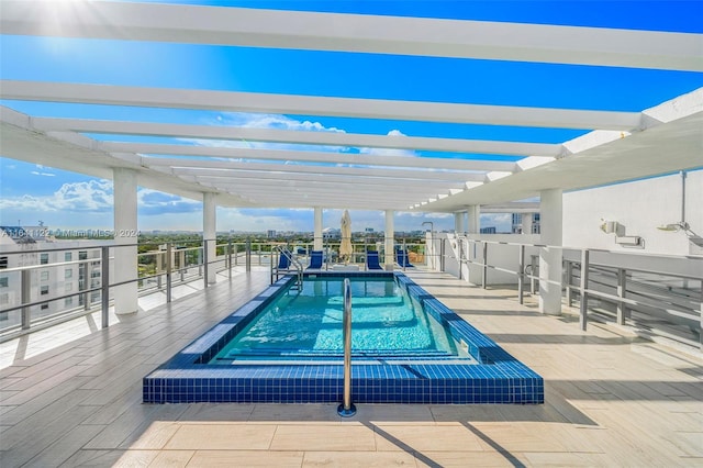 view of swimming pool with a hot tub and a pergola