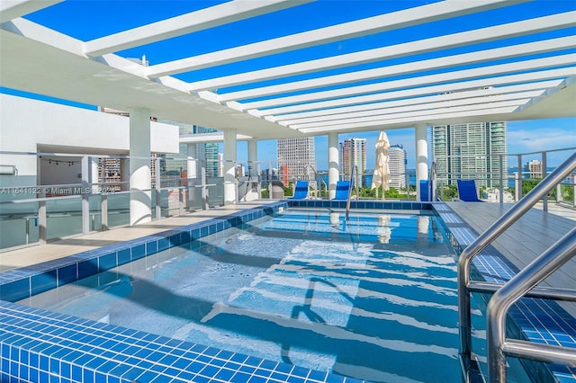 view of pool with a pergola and area for grilling