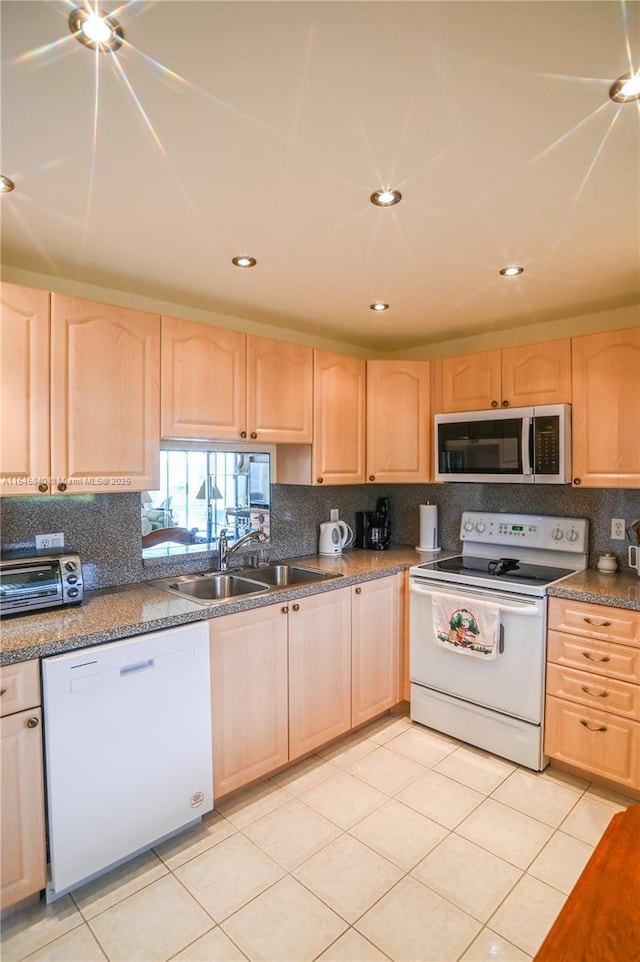 kitchen with light tile patterned floors, white appliances, light brown cabinetry, and sink