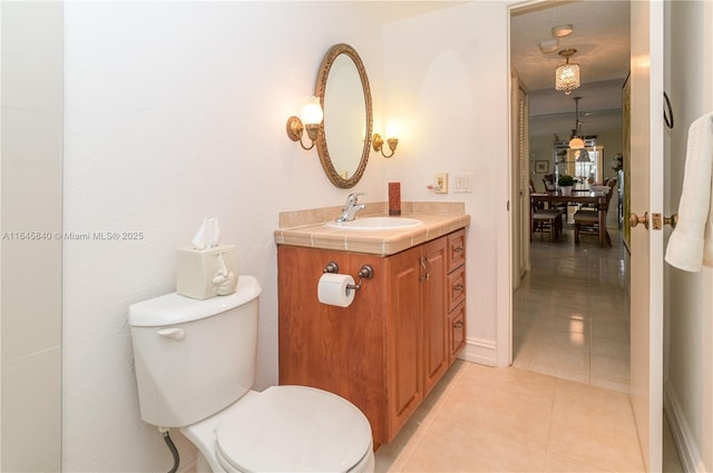 bathroom with toilet, vanity, and tile patterned floors