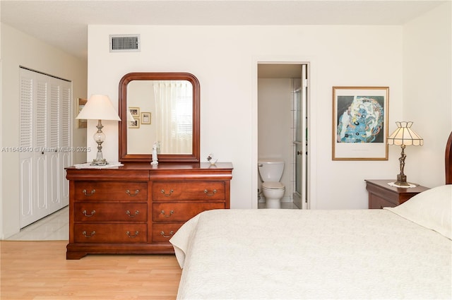 bedroom featuring ensuite bathroom, a closet, and light hardwood / wood-style flooring