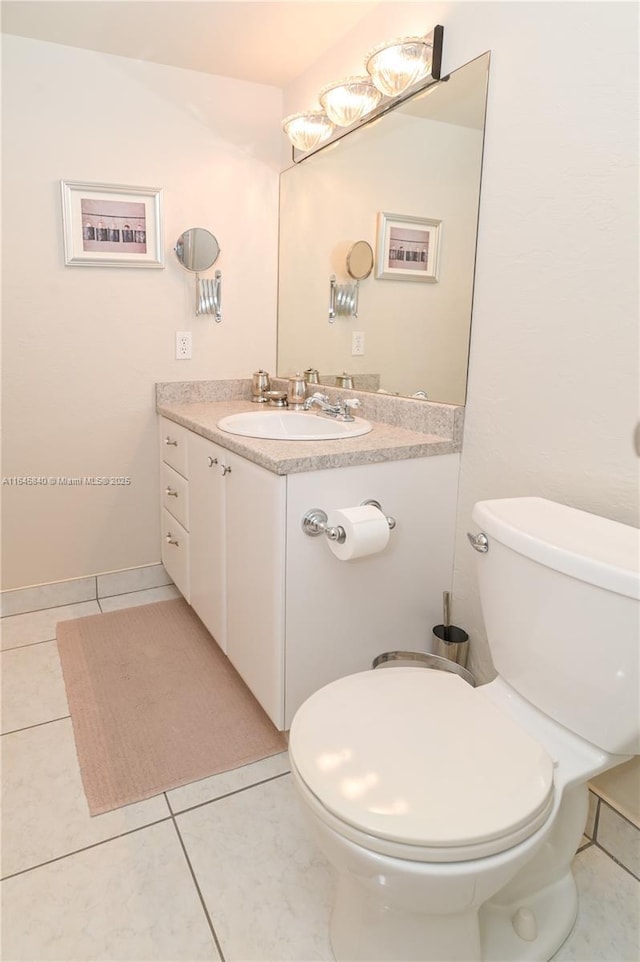 bathroom with tile patterned flooring, vanity, and toilet