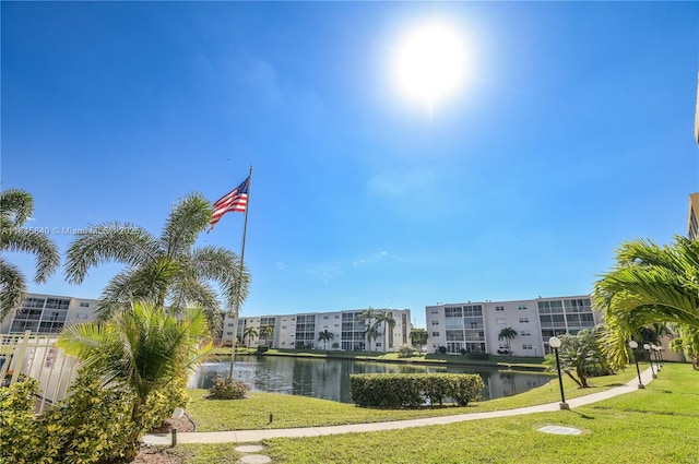 view of home's community featuring a lawn and a water view