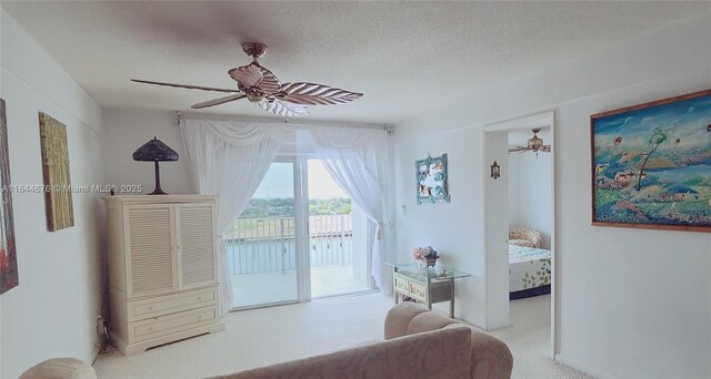 interior space with access to exterior, a textured ceiling, and ceiling fan