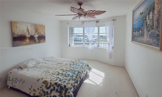 carpeted bedroom featuring a textured ceiling and ceiling fan