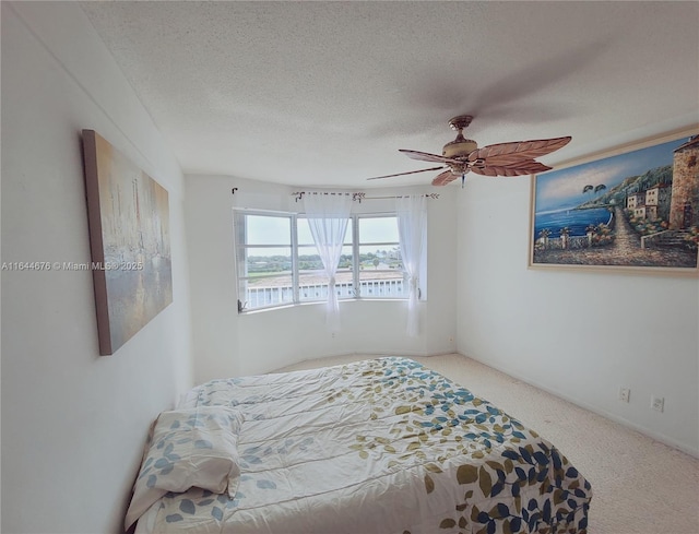 carpeted bedroom featuring a textured ceiling and ceiling fan