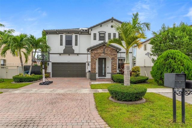 view of front of home with stone siding, decorative driveway, fence, and stucco siding