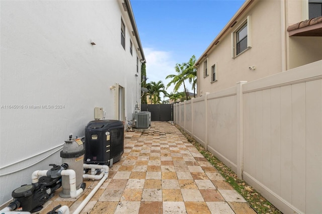 view of home's exterior with stucco siding, a fenced backyard, central AC, and a patio