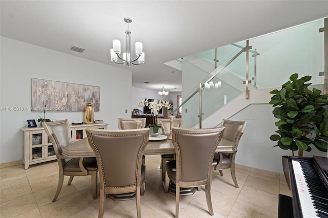 dining area with light tile patterned floors and an inviting chandelier