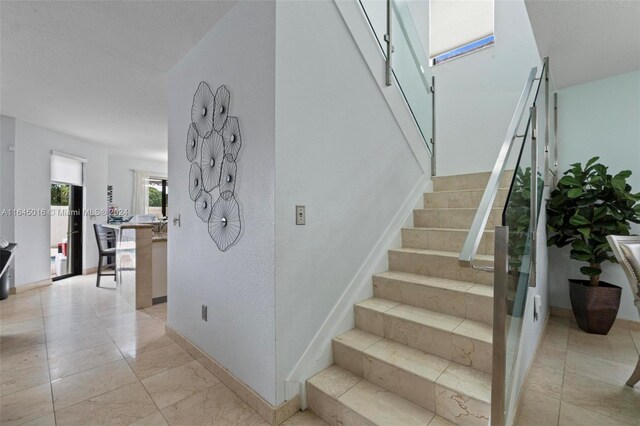 staircase featuring tile patterned flooring