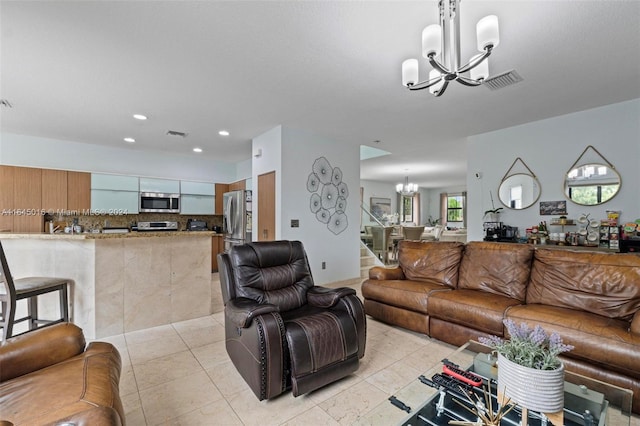 living room featuring a notable chandelier and light tile patterned flooring